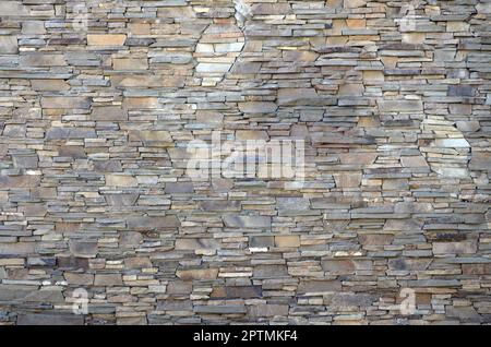 Modern pattern of flatten stone wall decorative surfaces in brown color. Stone lined with granite wall facing Stone rock Stock Photo