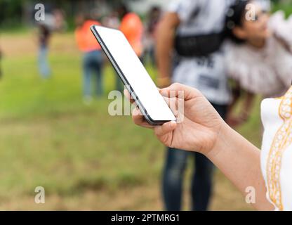 Close up of woman hand using mobile smartphone with blank screen outdoors Stock Photo