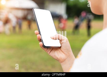 Close up of woman hand using mobile smartphone with blank screen outdoors Stock Photo