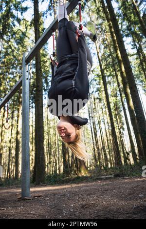 Fit woman doing pull ups with gymnastic rings at the gym or at fitness  studio as part of a fat-burning muscle-defining and stretching workout  routine Stock Photo - Alamy