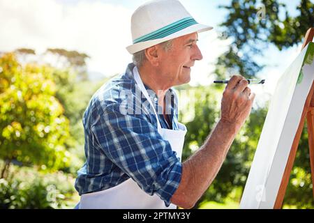 Nature needs to be painted. a senior man painting in the park. Stock Photo