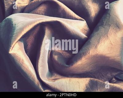 Beautiful fabric - taffeta, gently folded in waves. Crumpled material that looks like silk or brocade. Overflow and color gradient at different lighti Stock Photo