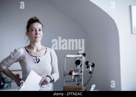 Portrait of a female healer holding the index card, Freiburg im Breisgau, Baden-Württemberg, Germany Stock Photo