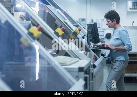 Female engineer working on computer in industry, Hanover, Lower Saxony, Germany Stock Photo
