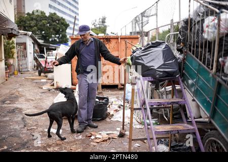 Hes my helper and friend. a man sorting through garbage at a dumping site Stock Photo