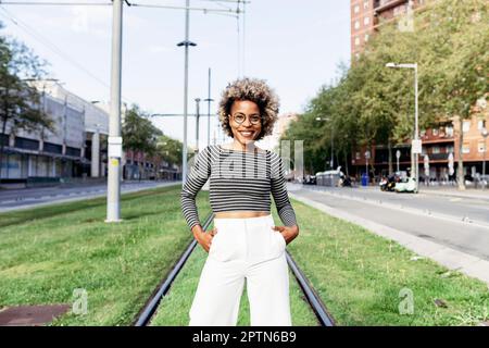 Portrait of Afro-American woman posing in the street with white pants Stock Photo