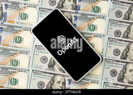 openai logo on the smartphone screen and US dollar bills next to it. Top view. Conceptual photo. March 30, 2023. Barnaul. Russia. Stock Photo