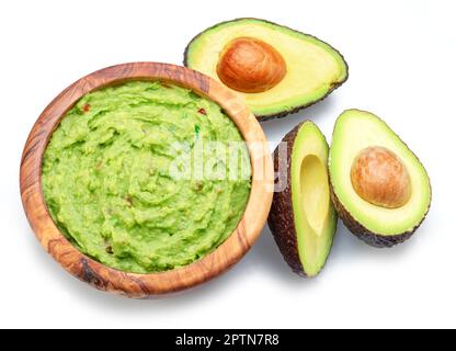 Guacamole and cross section of avocado fruits isolated on white background. Stock Photo