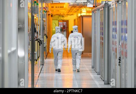 Dresden, Germany. 26th Apr, 2023. Female employees of the chip company Infineon walk along the clean room of the chip factory. Infineon breaks ground for the new Smart Power Fab in Dresden on May 2, 2023. Credit: Robert Michael/dpa/Alamy Live News Stock Photo