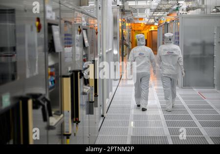 Dresden, Germany. 26th Apr, 2023. Female employees of the chip company Infineon walk along the clean room of the chip factory. Infineon breaks ground for the new Smart Power Fab in Dresden on May 2, 2023. Credit: Robert Michael/dpa/Alamy Live News Stock Photo