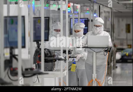 Dresden, Germany. 26th Apr, 2023. Employees of the Infineon chip group work in the clean room of the chip factory. Infineon breaks ground for the new Smart Power Fab in Dresden on May 2, 2023. Credit: Robert Michael/dpa/Alamy Live News Stock Photo