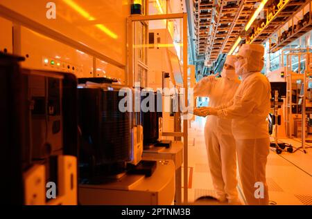 Dresden, Germany. 26th Apr, 2023. Employees of the Infineon chip group work in the clean room of the chip factory. Infineon breaks ground for the new Smart Power Fab in Dresden on May 2, 2023. Credit: Robert Michael/dpa/Alamy Live News Stock Photo