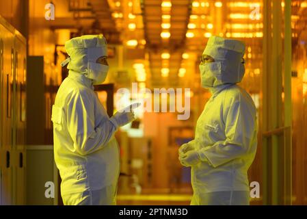 Dresden, Germany. 26th Apr, 2023. Employees of the Infineon chip group stand in the clean room of the chip factory. Infineon breaks ground for the new Smart Power Fab in Dresden on May 2, 2023. Credit: Robert Michael/dpa/Alamy Live News Stock Photo