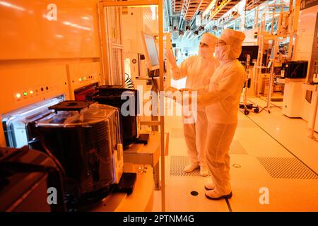 Dresden, Germany. 26th Apr, 2023. Employees of the Infineon chip group work in the clean room of the chip factory. Infineon breaks ground for the new Smart Power Fab in Dresden on May 2, 2023. Credit: Robert Michael/dpa/Alamy Live News Stock Photo