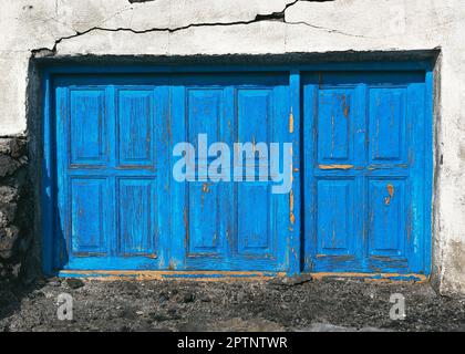 Old blue window with three closed shutters of old house. Facade detail, doors and windows. Vintage background, texture. La Palma, Canary Islands. Stock Photo