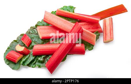 Red rhubarb stems' cuts over rhubarb leaves isolated on white background. Stock Photo