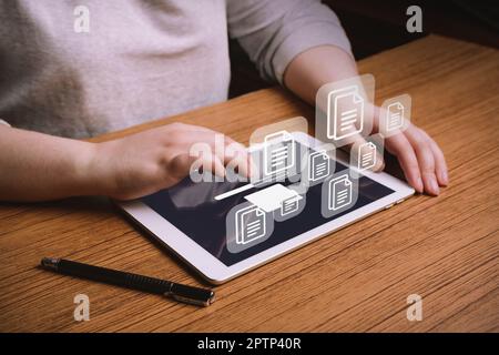 Woman working on laptop to Document Management System (DMS). Software for archiving, searching and managing corporate files and information. Stock Photo