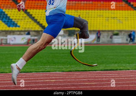 male runner para athlete on limb deficiency running track stadium, summer para athletics championships Stock Photo