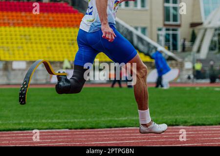 close-up male para athlete on limb deficiency running track stadium, summer para athletics championships Stock Photo