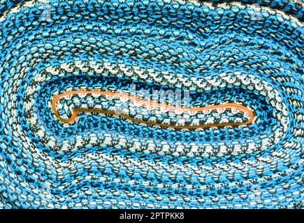 Vibrant blue colored curving lined of rolled up Peruvian fabric for sale in downtown Cuzco, Peru, South America Stock Photo