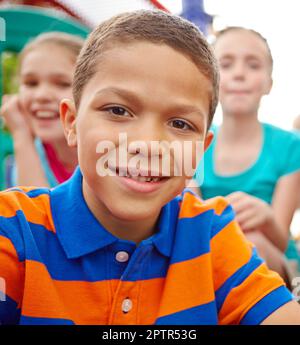 Giving you an innocent smile. A multi-ethnic group of happy children playing on a jungle gym in a play park Stock Photo