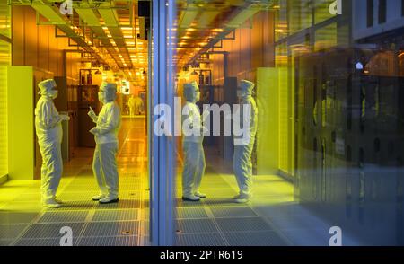 Dresden, Germany. 26th Apr, 2023. Employees of the Infineon chip group stand in the clean room of the chip factory. Infineon breaks ground for the new Smart Power Fab in Dresden on May 2, 2023. Credit: Robert Michael/dpa/Alamy Live News Stock Photo