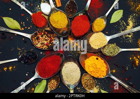 Spices and seasonings for cooking in spoons on a dark background. Stock Photo