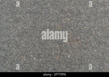 Monochromatic texture of granite surface. Detailed photo of the treated glossy granite stone, which is used as tiles for walls and floors Stock Photo