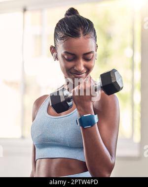 Woman, dumbbell and music earphones in gym workout, training and