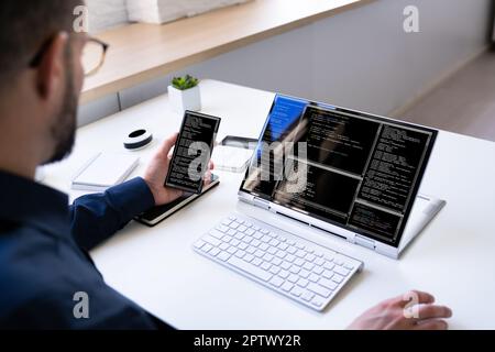 Programmer Or Coder At Office Desk Using Laptop Stock Photo