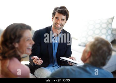 Sharing good news about their investments. A young consultant giving advice to a mature couple Stock Photo