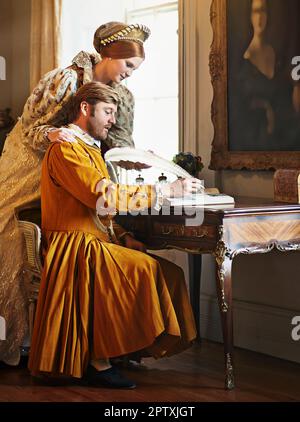 We must dispatch this letter quickly. an aristocratic couple writing a letter at an ornate table Stock Photo