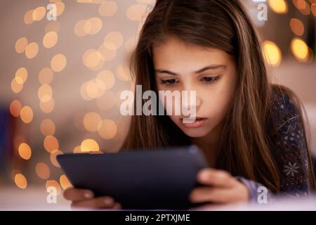 Who knew you could find so many things on the internet. a cute little girl using a digital tablet Stock Photo