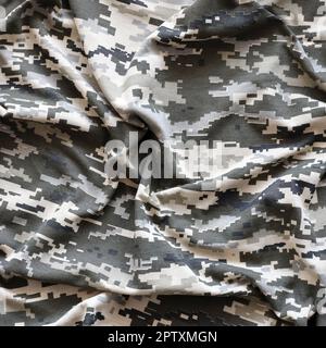 Fabric with texture of Ukrainian military pixeled camouflage. Cloth with camo pattern in grey, brown and green pixel shapes. Official uniform of Ukrai Stock Photo