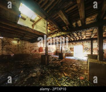 Interior of an abandoned storage building with bright daylight coming from outside. Stock Photo