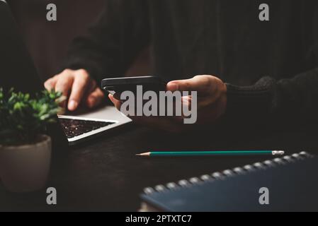 man using mobile smart phone and working on laptop computer.education and technology concept, student working, Freelance. Stock Photo