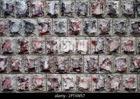 Texture design of the foundation or walls of buildings in the form of rectangular tiles made of solid granite stone with sharp corners. Several rows o Stock Photo