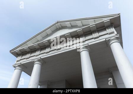 White columns and portico under blue sky, classic architecture template. Wooden temple exterior in Neoclassical Roman style Stock Photo