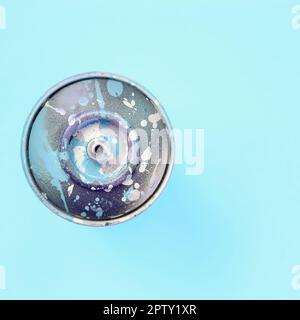 Used spray can with blue paint drips lie on texture background of fashion pastel blue color paper in minimal concept. Stock Photo