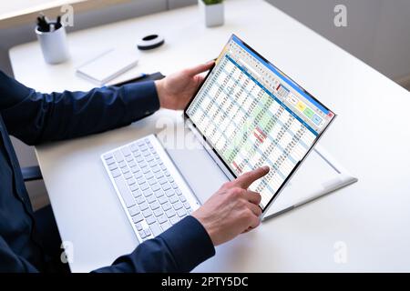 Electronic Spreadsheet Analyst Or Auditor Using Software On Hybrid Laptop Stock Photo