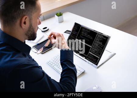 Programmer Or Coder At Office Desk Using Laptop Stock Photo