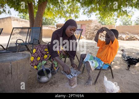 A mother cooks over a small charcoal stove in Segou Region, Mali, West Africa. 2022 Mali drought and hunger crisis. Stock Photo