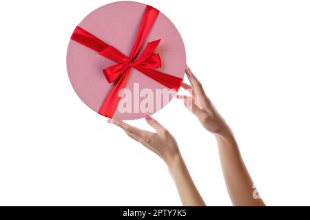 Female hands with pink round gift box isolated on white. Stock Photo