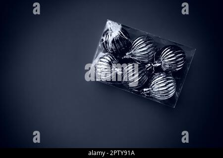 Box with Christmas tree decorations. Gift or purchase. Happy New Year and Merry Christmas. Shiny balls in a package. Black and white monochrome photo Stock Photo