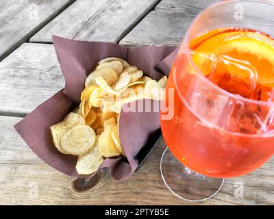 Spritz Aperol with chips, for a perfect pre-dinner. Classic Italian aperitif. Stock Photo