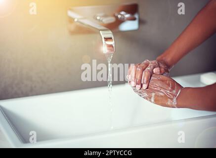 Keeping her hands clean. an unrecognizable woman washing her hands in the bathroom Stock Photo