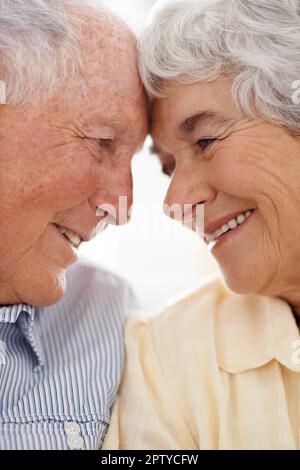 You can still see the love in their eyes. An aged couple at home together Stock Photo