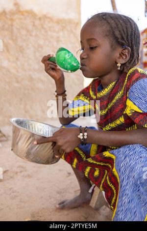 Fulani IDP girl eating morning porridge in Segou Region, Mali, West Africa. 2022 Mali drought and hunger crisis. Stock Photo