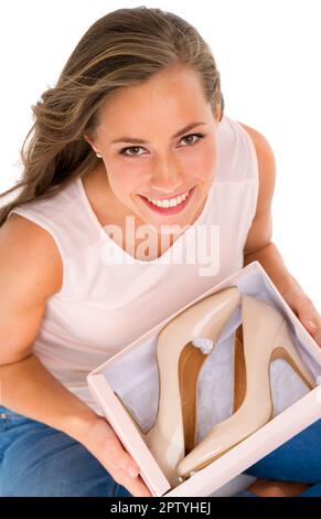 She keeps up to date with the latest fashion trends. High angle shot of an attractive young woman holding a box of new high heels against a white back Stock Photo
