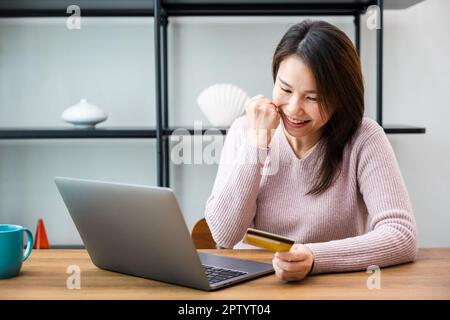 Asian businesswoman raised hands up she excited and happy amazed read good news from laptop computer at office, woman positive excited crazy smiling c Stock Photo